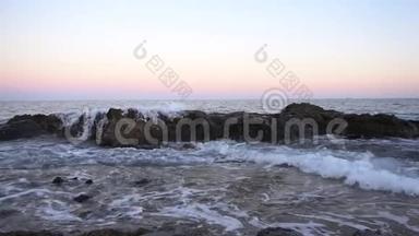 波在地中海上.. 波浪在粉红色日落<strong>时撞击</strong>岩石。 慢动作